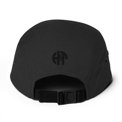 Classic HFT five-panel cap featuring a low profile fit, a nylon strap clip closure at the back with an adjustable strap, and a subtle HFT logo on the rear, set against a plain backdrop for a clean presentation back