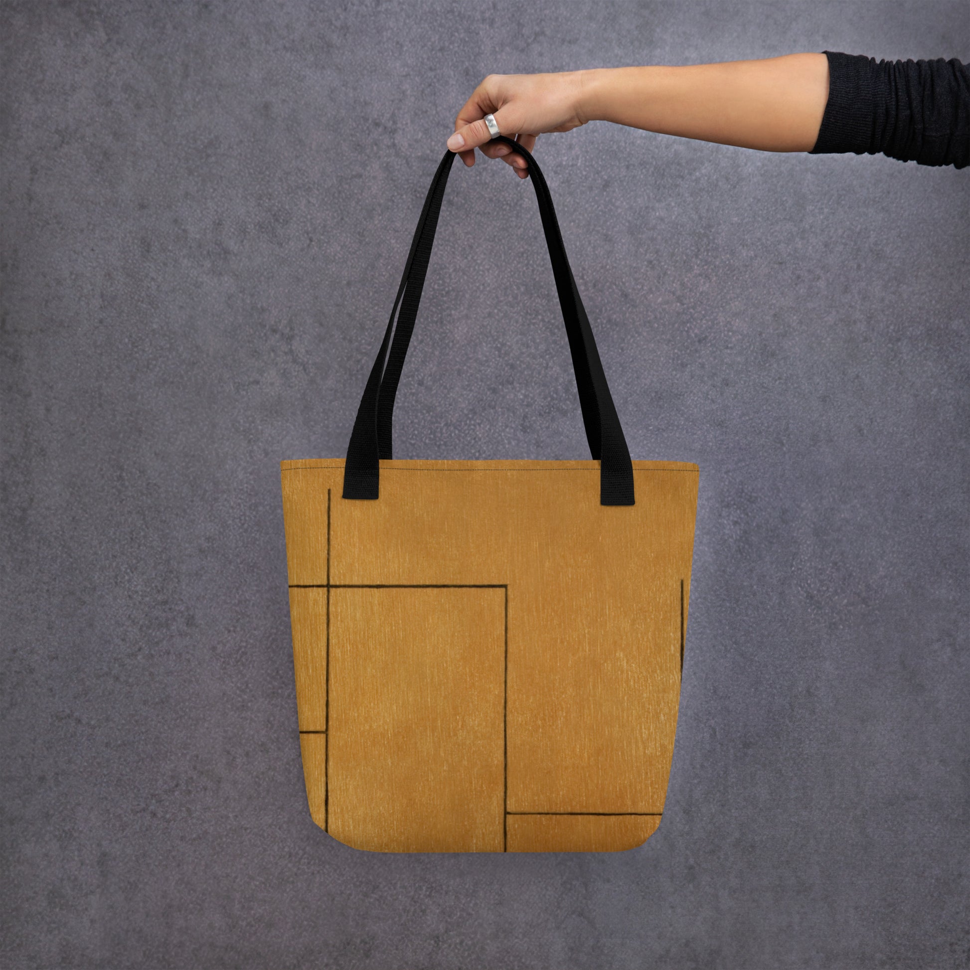 person hold HFT Tote Bag I in a stylish camel brown color with black handles, shows off its spacious design and external pocket detail