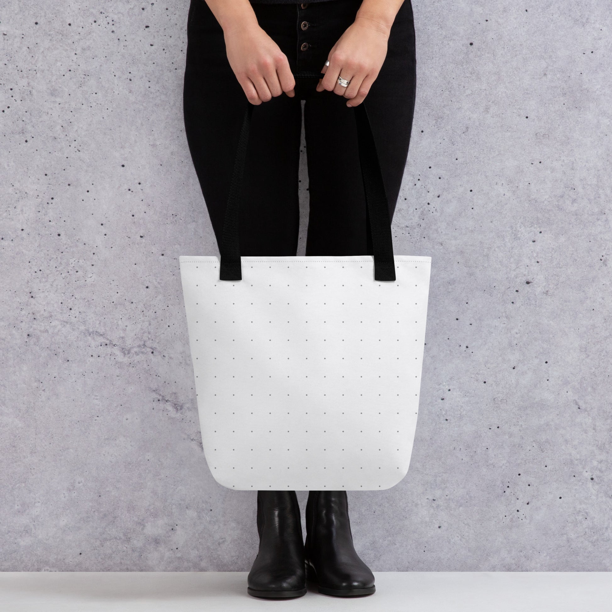 Person holding an HFT Tote Bag III, showcasing the bag's spacious and trendy design with a polka dot pattern against a concrete background