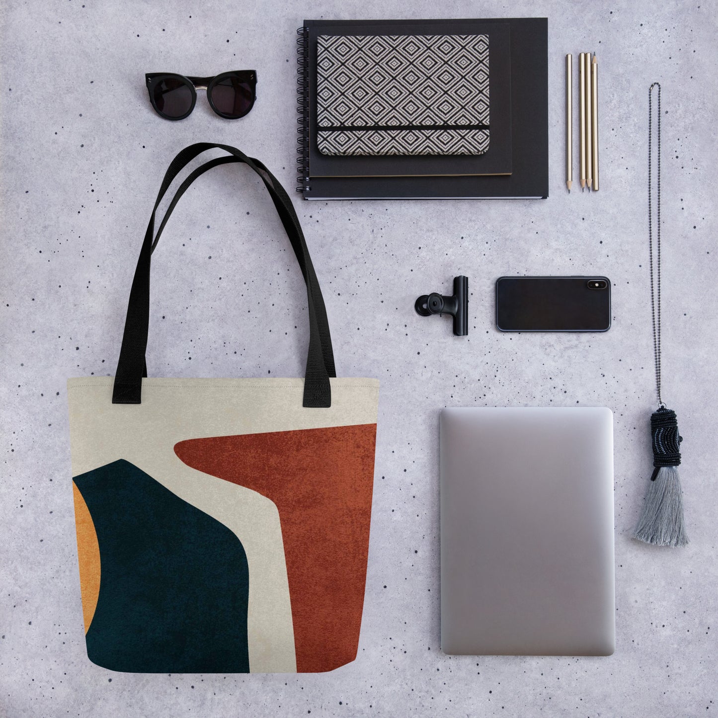 a HFT Tote Bag IV with abstract geometric design, showcasing rich earth tones setup against a textured gray background.