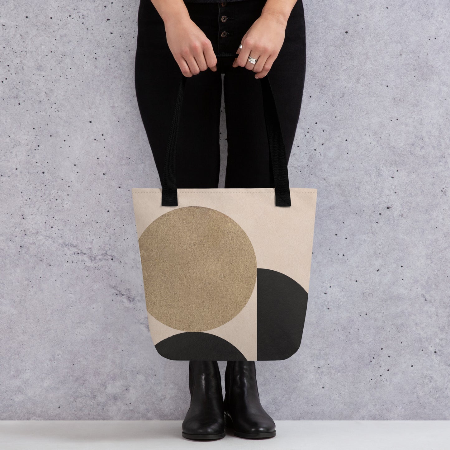 Person holding a HFT Tote Bag V with abstract geometric design, showcasing rich earth tones setup against a textured gray background