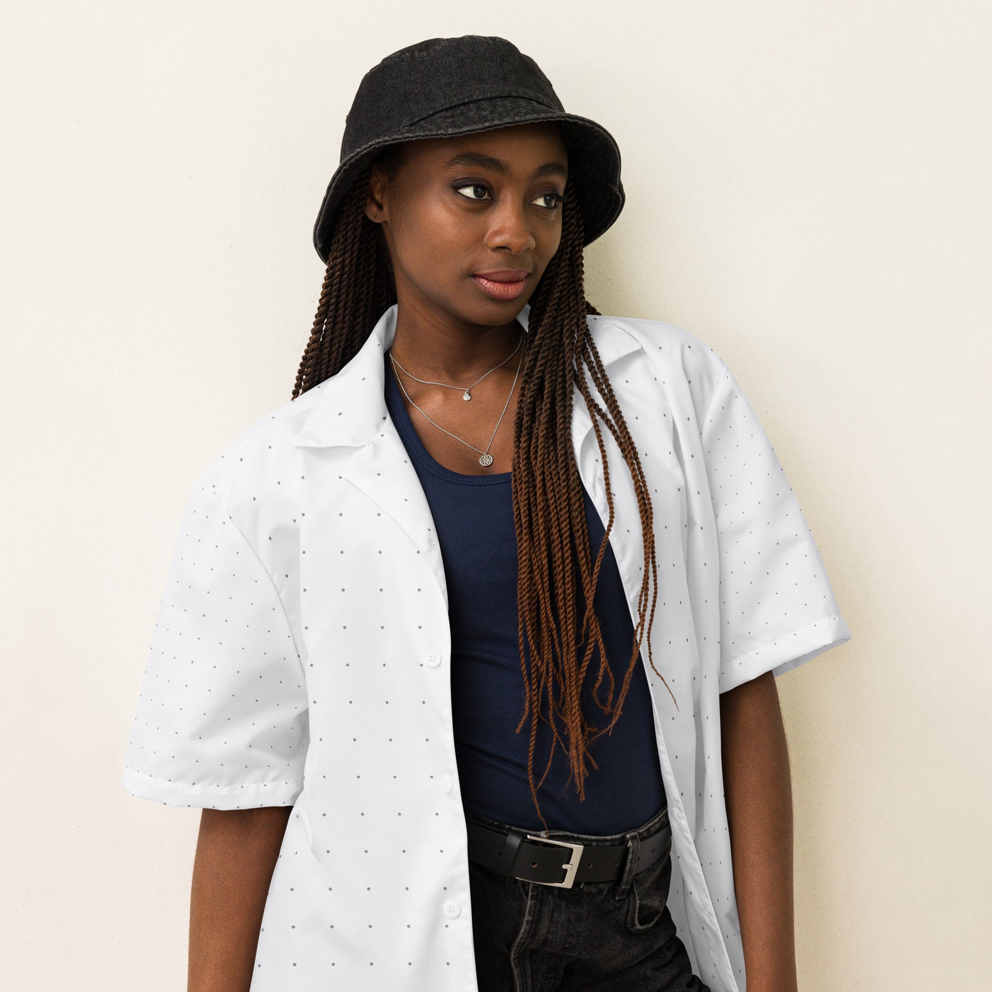 Crisp white unisex button-down shirt with a subtle black dot pattern, short sleeves, and a comfortable fit right