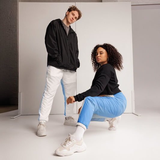 legant HFT Unisex Track Pants III in a color-block design with white and light blue panels, featuring water-resistant fabric, mesh lining, and elastic ankle cuffs 2models