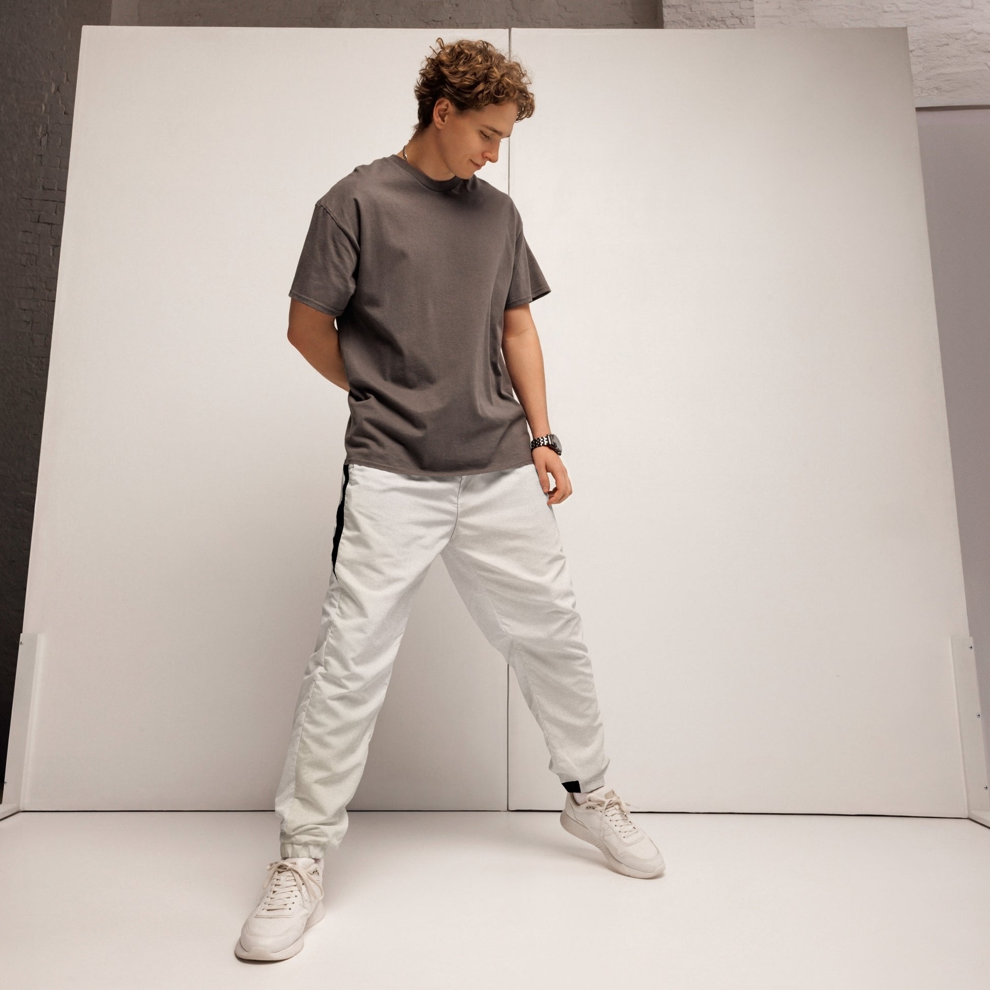 Pair of HFT Unisex Track Pants IV in a crisp white color with contrasting black side stripes, elastic waistband, and cuffs, laid flat on a white background front