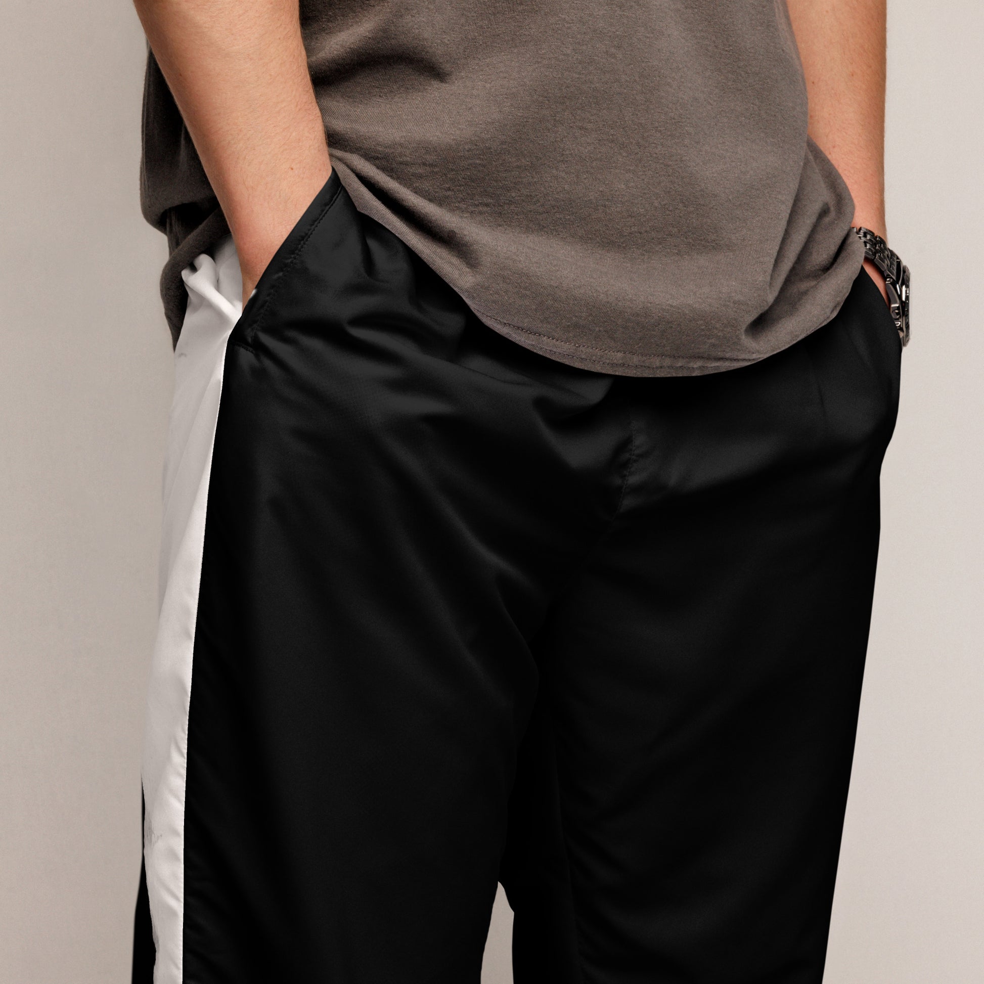 Stylish black and white HFT unisex track pants with water-resistant and lightweight fabric, featuring elastic ankle cuffs and mesh lining, laid flat. zoom in