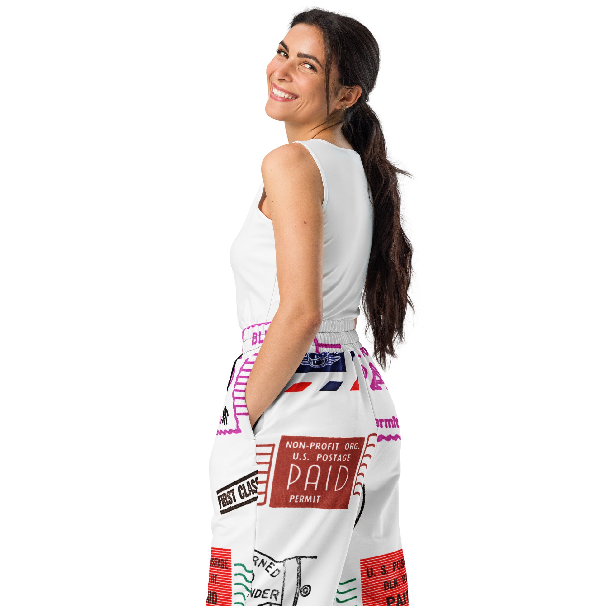 Trendy unisex HFT wide-leg joggers with an all-over postal print design, featuring a mix of U.S. postage paid stamps and permit labels, in a black, red, and blue color scheme on a white background female