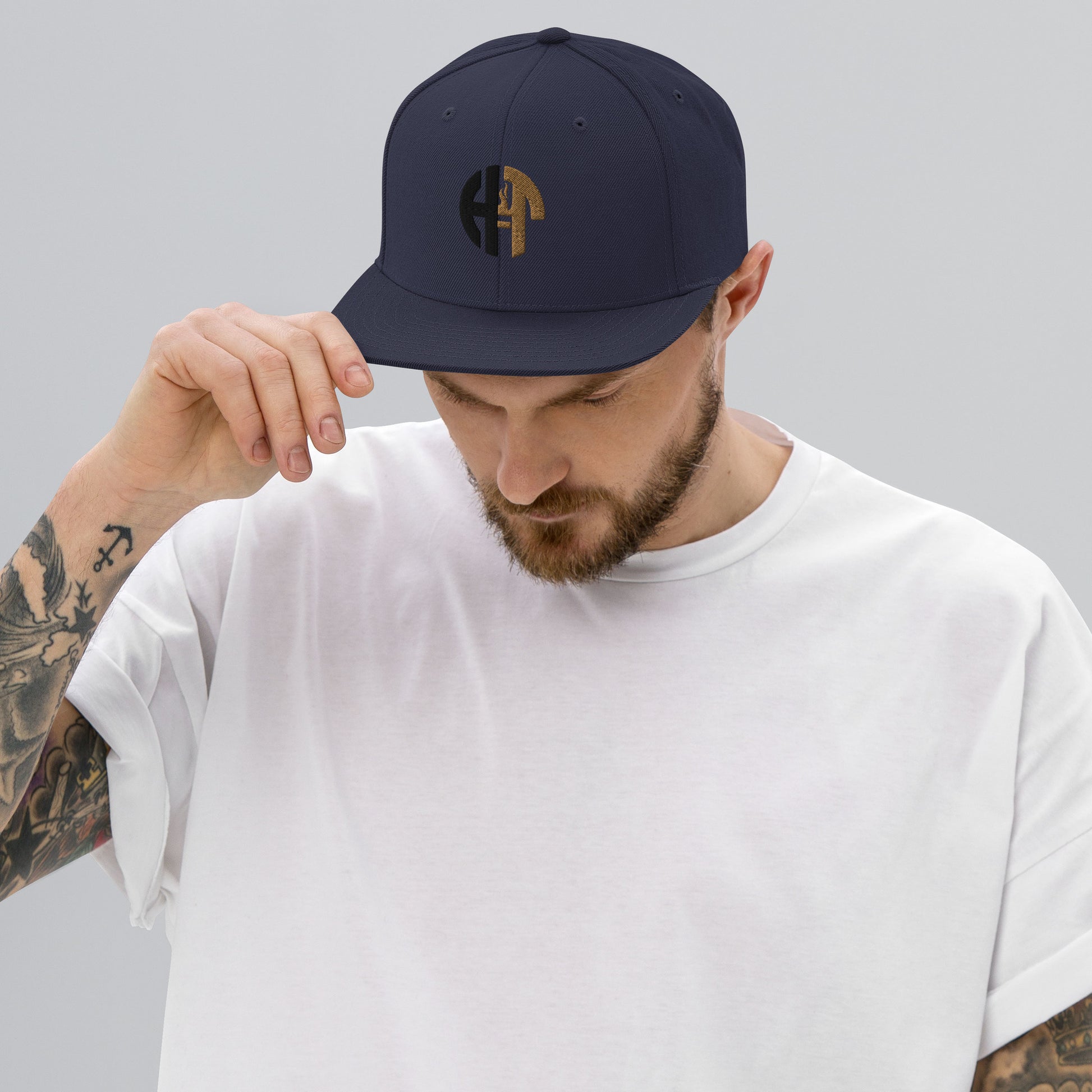 A stylish two-tone hat with a classic fit,The front displays an embroidered 'HFT' logo in black and gold. An adjustable snap closure at the back provides a comfortable and custom fit for most head sizes  navy model