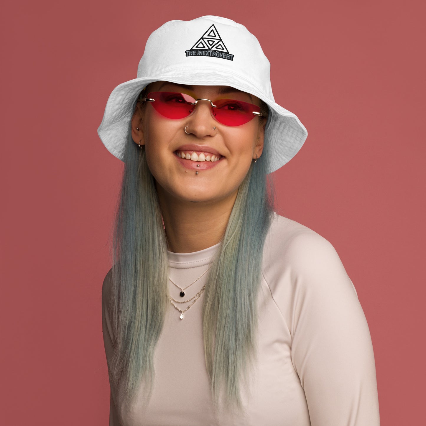 The Inextrovert Organic Bucket Hat made of 100% cotton twill with a boldtriangle logo, showcasing a minimalist and breathable design, casting a soft shadow on a bright surface white