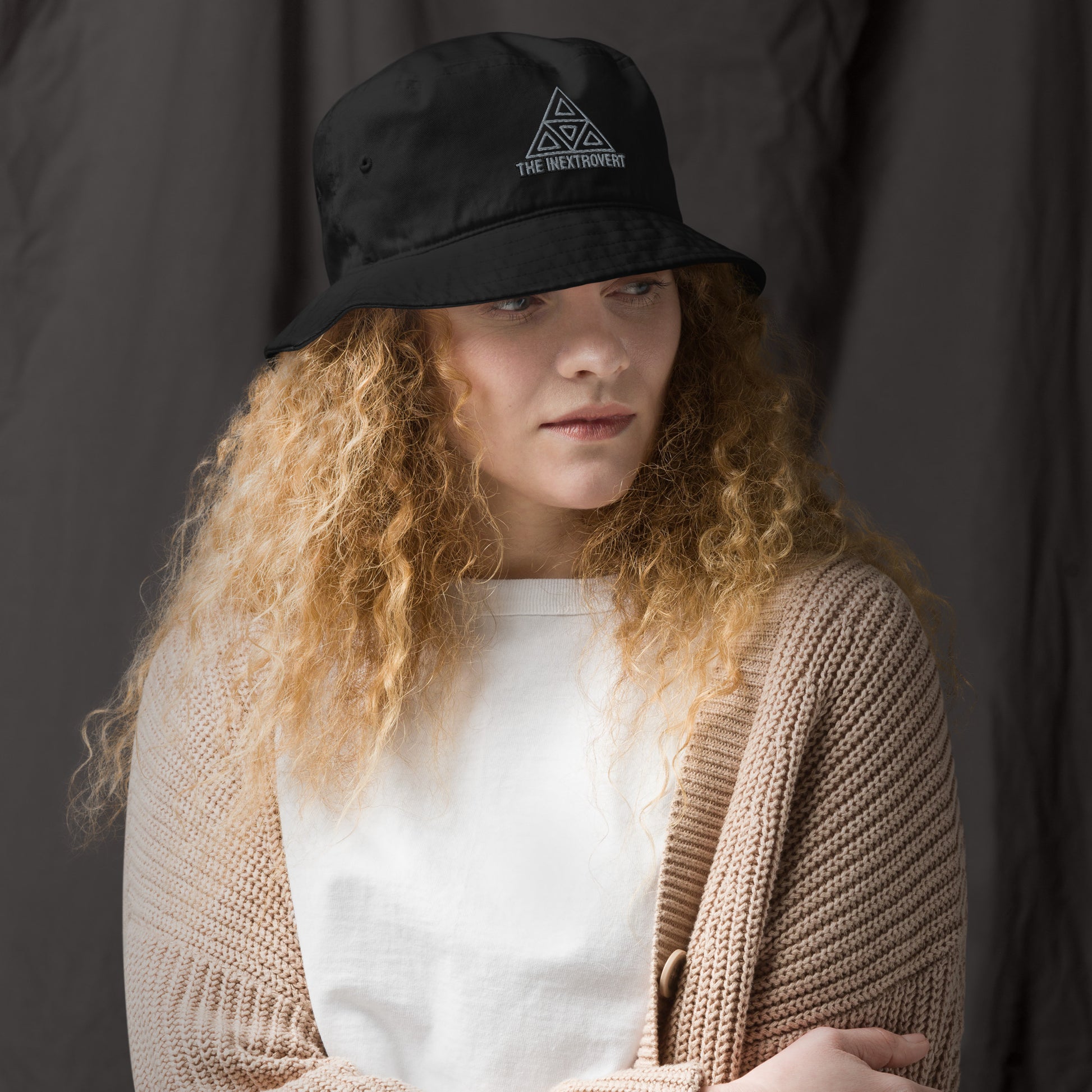 The Inextrovert Organic Bucket Hat made of 100% cotton twill with a boldtriangle logo, showcasing a minimalist and breathable design, casting a soft shadow on a bright surface black front