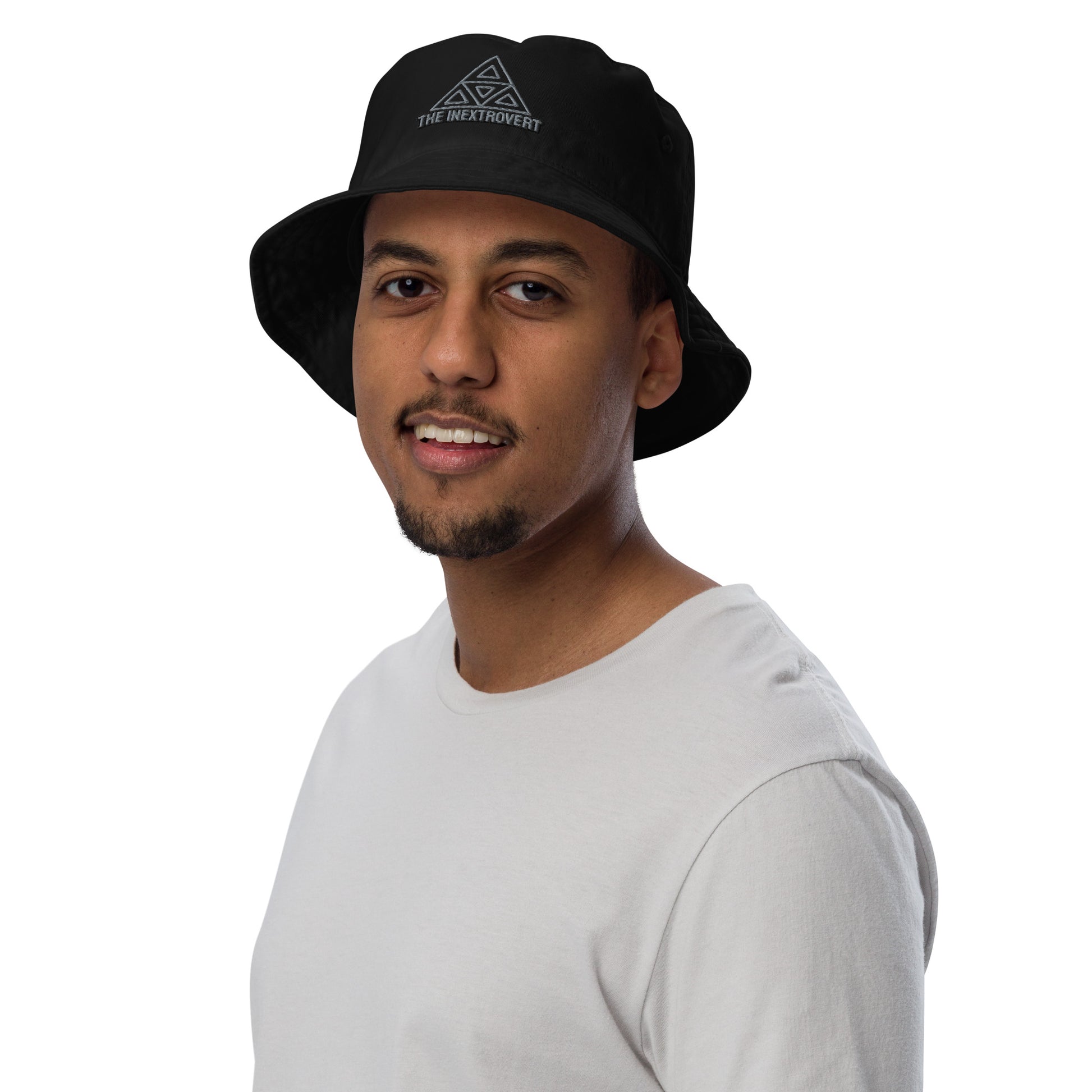 The Inextrovert Organic Bucket Hat made of 100% cotton twill with a boldtriangle logo, showcasing a minimalist and breathable design, casting a soft shadow on a bright surface black male