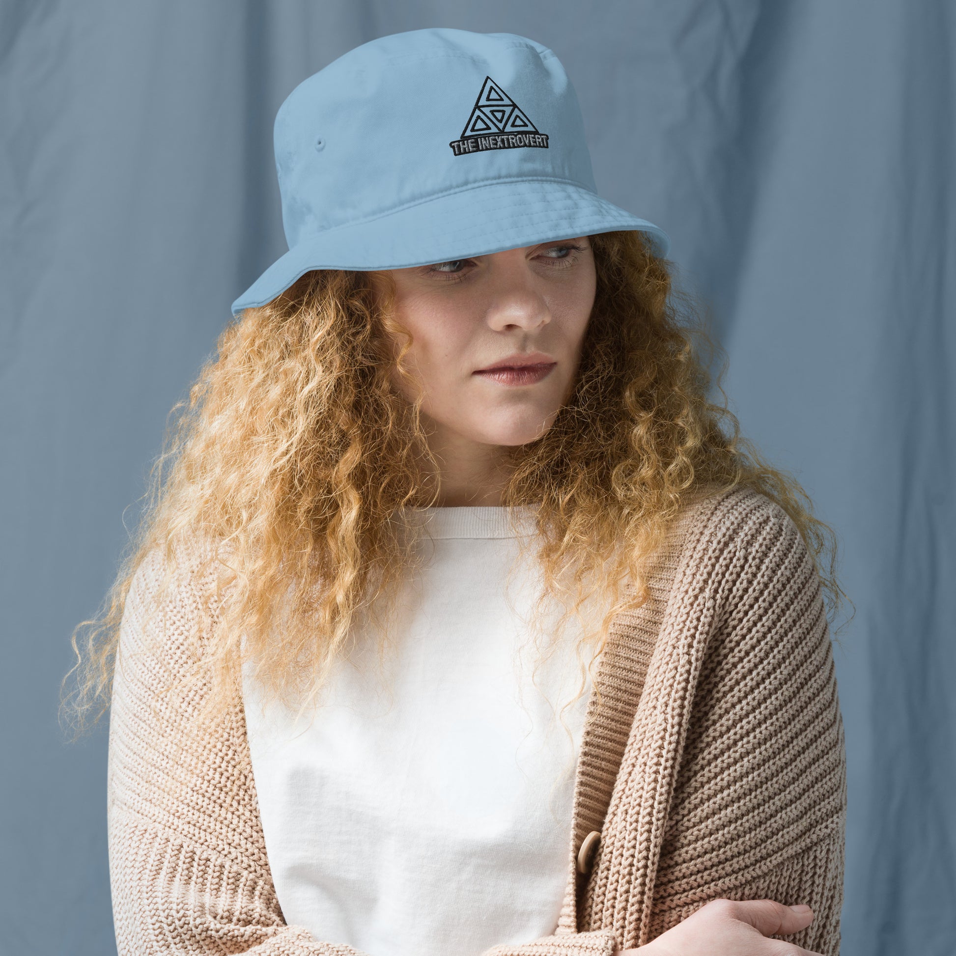 The Inextrovert Organic Bucket Hat made of 100% cotton twill with a boldtriangle logo, showcasing a minimalist and breathable design, casting a soft shadow on a bright surface stale blue front