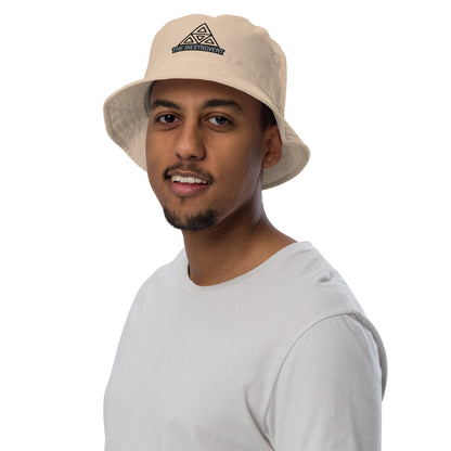 The Inextrovert Organic Bucket Hat made of 100% cotton twill with a boldtriangle logo, showcasing a minimalist and breathable design, casting a soft shadow on a bright surface stone front male