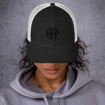 A stylish six-panel trucker cap with a breathable mesh back and a front panel featuring a black 'HFT' logo, complete with a pre-curved brim and an adjustable snap closure for comfort black white