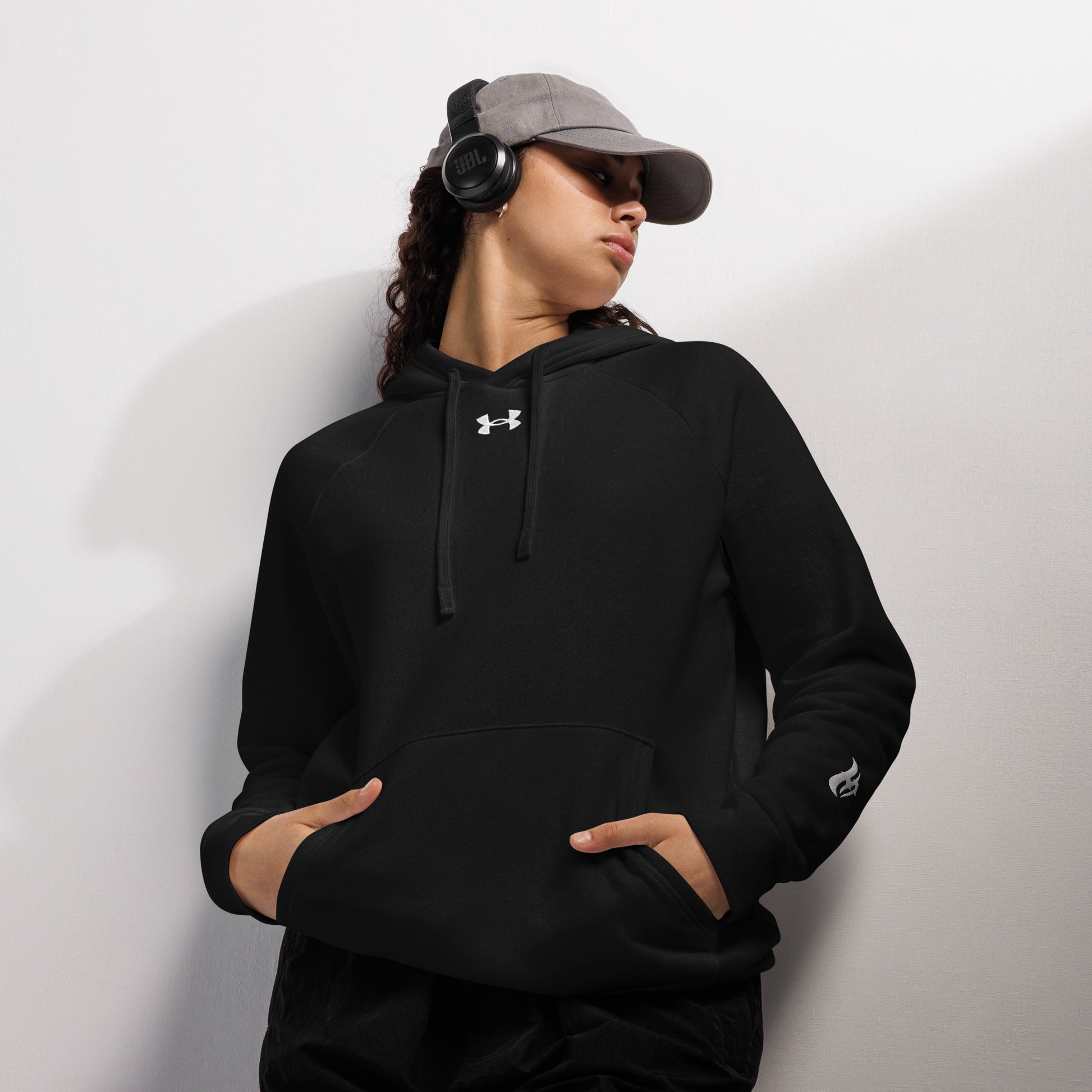 Woman wearing a black  HFT Under Armour® Hoodie with a relaxed fit, showcasing comfort and a subtle logo, perfect for casual or active wear